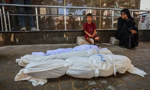 Palestinian woman and son stand next to the bodies of those killed in an Israeli attack in Gaza City Palestinian woman and son stand next to the bodies of those killed in an Israeli attack in Gaza City