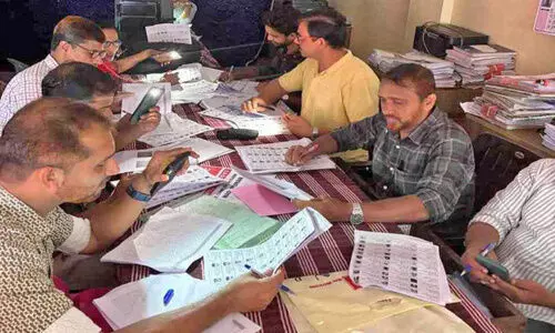 B.L.Omar is conducting voter list verification at the Nadapuram Village Office through mobile phone