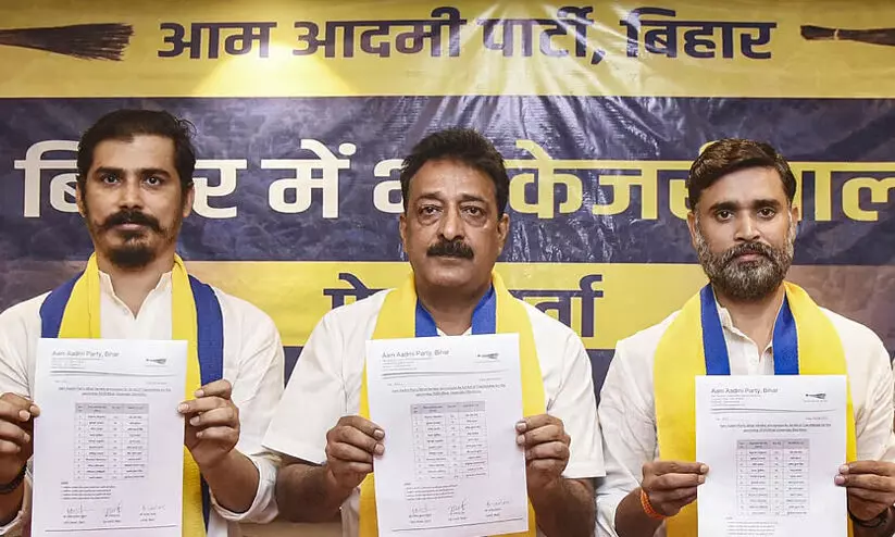 Ajesh Yadav (centre) and Rakesh Yadav (right) release the list of candidates for the Bihar elections.