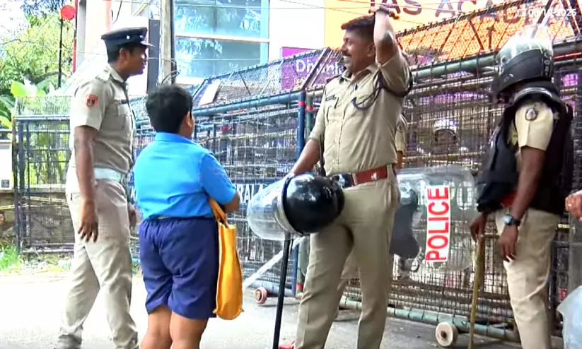 മാർഗതടസ്സമായി പൊലീസിന്റെ ബാരിക്കേഡ്; ‘വീട്ടിലേക്ക് പോണം, എനിക്ക് ചോറുവേണം’ പൊലീസുകാരോട് പരിഭവം അറിയിച്ച് വിദ്യാർഥി മാർഗതടസ്സമായി പൊലീസിന്റെ ബാരിക്കേഡ്; ‘വീട്ടിലേക്ക് പോണം, എനിക്ക് ചോറുവേണം’ പൊലീസുകാരോട് പരിഭവം അറിയിച്ച് വിദ്യാർഥി