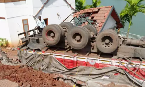 നിർത്തിയിട്ട ലോറി റോഡ് ഇടിഞ്ഞ് വീടിന് മുകളിലേക്ക് മറിഞ്ഞു
