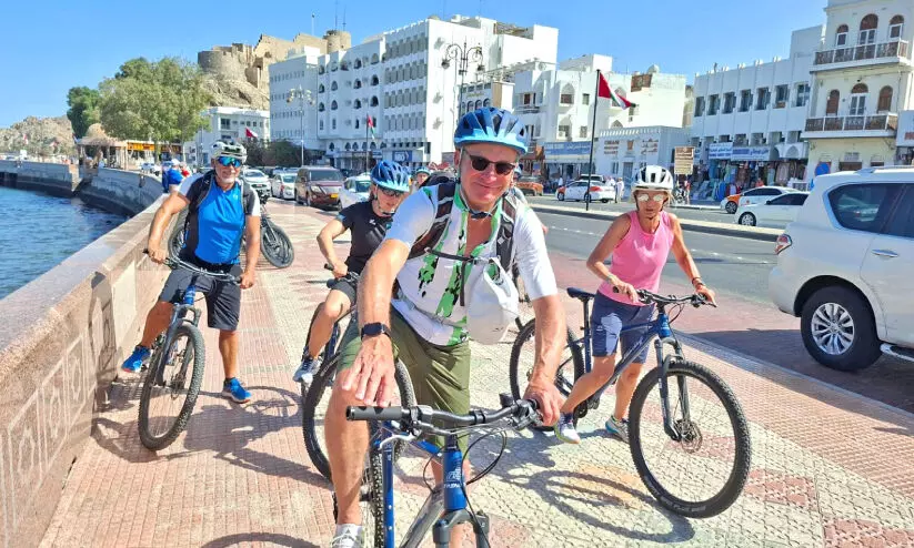 ക്രൂസ് കപ്പലിൽ വന്നിറങ്ങിയ വിനോദസഞ്ചാരികൾ മത്രയിൽ സൈക്കിൾ സവാരിക്കിടെ