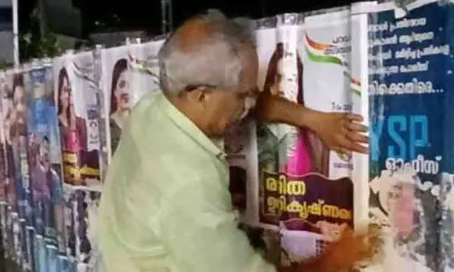 സ്ഥാനാർഥിയായ മകൾക്കുവേണ്ടി പോസ്റ്റർ ഒട്ടിക്കാൻ പിതാവ് സ്ഥാനാർഥിയായ മകൾക്കുവേണ്ടി പോസ്റ്റർ ഒട്ടിക്കാൻ പിതാവ്