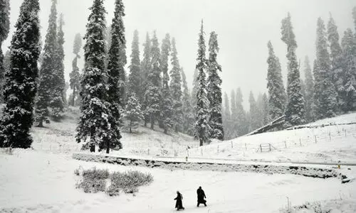 Kashmiri natives cross a snow covered area at Gulmarg