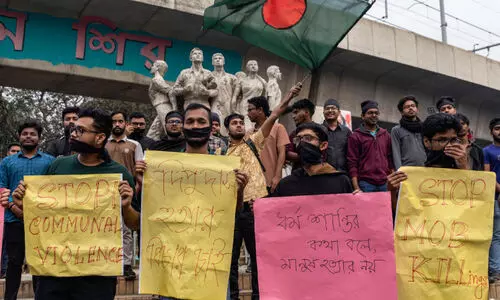 Students protesting by wearing black cloth near the Raju memorial sculpture at Dhaka University