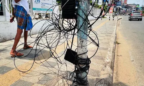 അ​പ​ക​ടം ക്ഷ​ണി​ച്ച് ന​ഗ​ര ന​ട​പ്പാ​ത​ക​ളി​ൽ കേ​ബി​ൾ കു​രു​ക്ക്