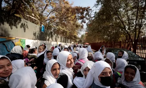 A group of Afghan schoolgirls standing together outside a school. A group of Afghan schoolgirls standing together outside a school.