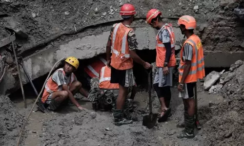 Rescue personnel assisting mud-covered workers pulled out alive from the Trishuli 3A hydropower tunnel in Nepal Rescue personnel assisting mud-covered workers pulled out alive from the Trishuli 3A hydropower tunnel in Nepal