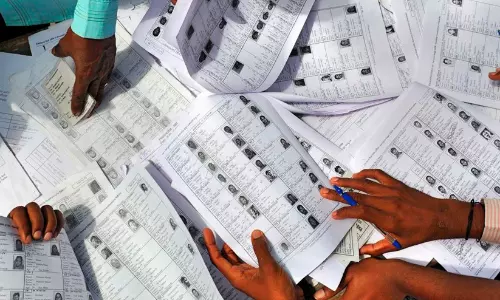 Migrant workers holding voter identification documents in Karnataka Migrant workers holding voter identification documents in Karnataka