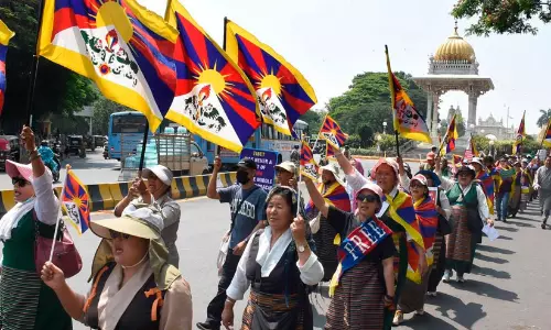 Tibetan Youth Congress members carrying Tibetan national flags and banners during a protest rally in Mysuru.