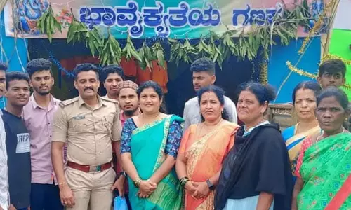 Jubedha standing with volunteers and community members in front of the Rajivnagara Ganesha festival pandal in Karnataka.