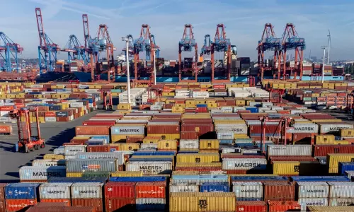 Container shipping terminal representing international trade and commerce between Bangladesh, the US, and India.