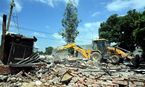 Bulldozer action at a demolition site involving alleged unauthorized structures in India.