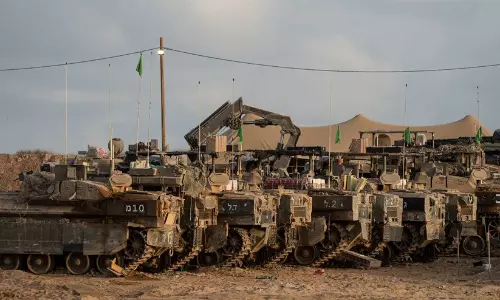 Israeli military outpost area in northern Gaza with military vehicles operating in the background