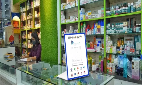 A digital payment QR code scanner being used for a transaction at a retail shop counter.