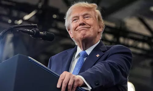 President Donald Trump speaking at a political rally podium alongside California state landmark references. President Donald Trump speaking at a political rally podium alongside California state landmark references.