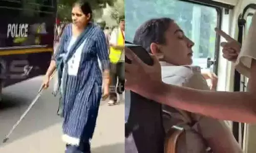 Protesters confronting a woman in civilian clothes with a baton assisting Delhi Police during student protests