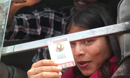 Journalists and media persons showing press ID cards amid police barricades during a protest in New Delhi. Journalists and media persons showing press ID cards amid police barricades during a protest in New Delhi.