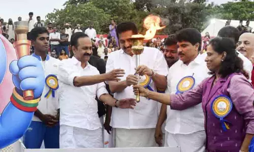 CM VD Satheesan lights the main torch at the Kerala State School Athletic Meet as PT Usha looks on