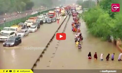 കനത്ത മഴ: വെള്ളക്കെട്ടിലൂടെ നടന്ന് നീങ്ങി യാത്രക്കാർ‍