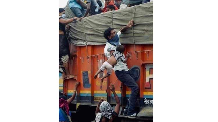 കൈക്കുഞ്ഞിനെ കൈയിൽ തൂക്കി ട്രക്കിലേക്ക്​; യാതനകളുടെ നേർസാക്ഷ്യമായി ആ ചിത്രം...