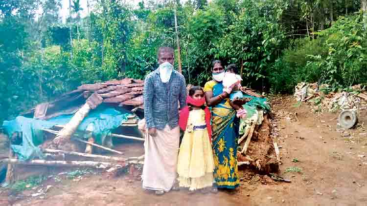 നിലംപൊത്തിയ വീടിനുമുന്നിൽ ഒരു കുടുംബം